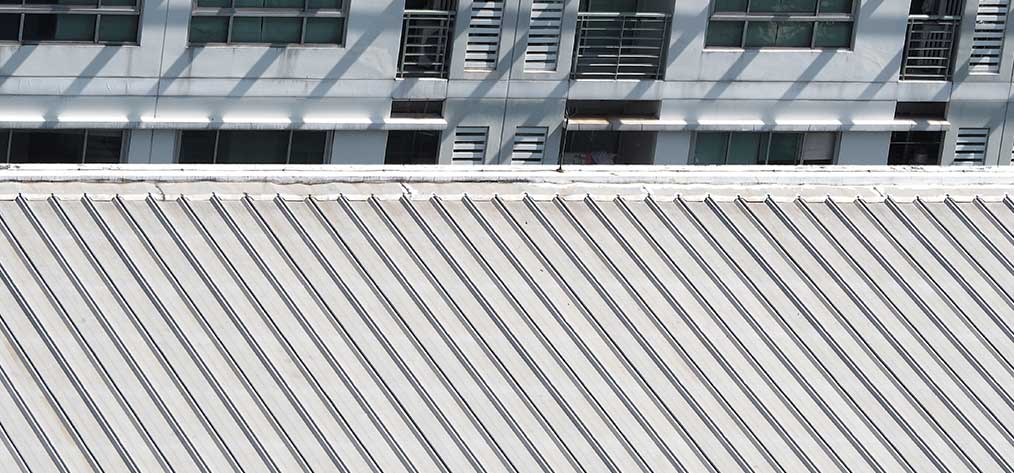 Long run steel roofing on a commercial building roof in Auckland, close up of ribbed roofing panels