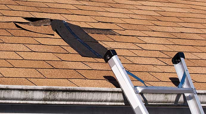 Damaged roof shingles ready for re-roofing in Auckland